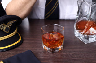 a man sitting at a table with a glass of alcohol