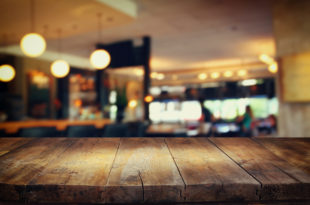 a wooden table in front of a restaurant