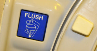 a blue flush button on a white surface