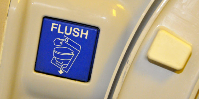 a blue flush button on a white surface