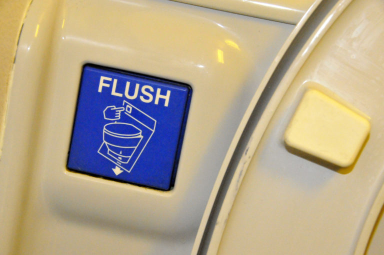 a blue flush button on a white surface