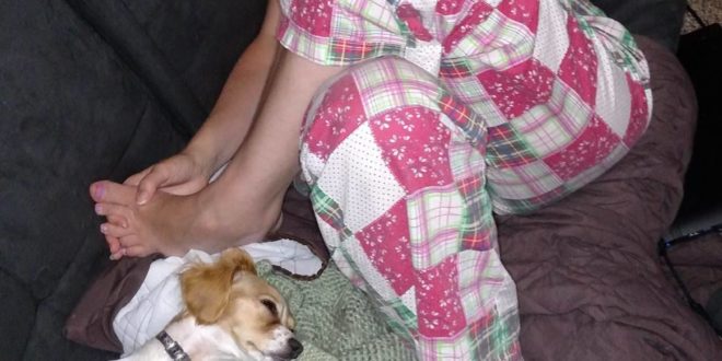 a woman lying on a couch with a dog
