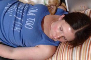 a woman sleeping with a dog