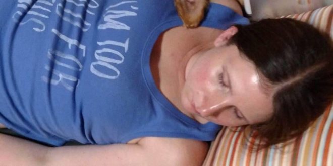 a woman sleeping with a dog