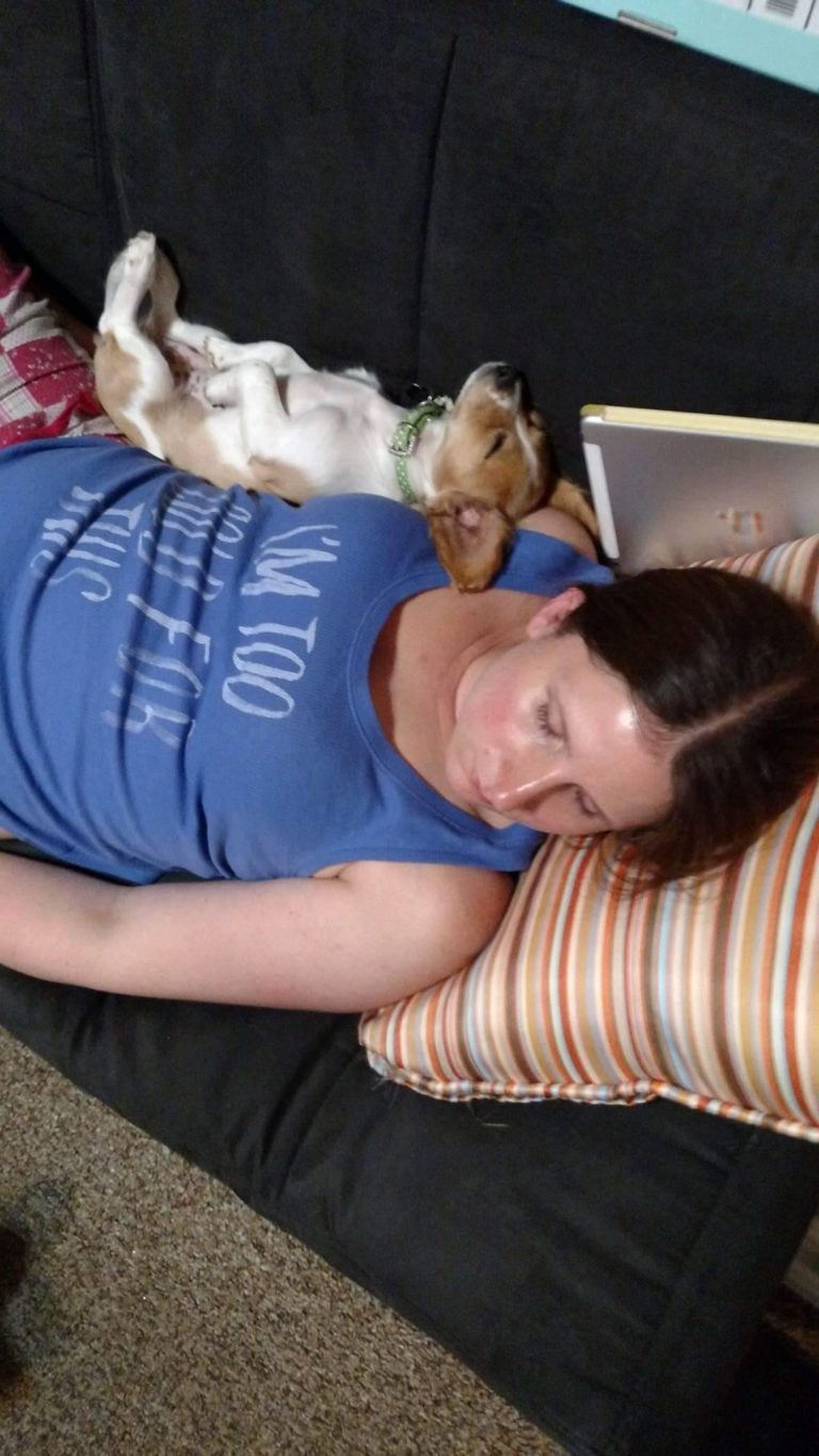 a woman sleeping with a dog