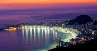a city with lights on the beach
