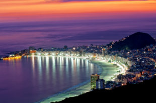 a city with lights on the beach