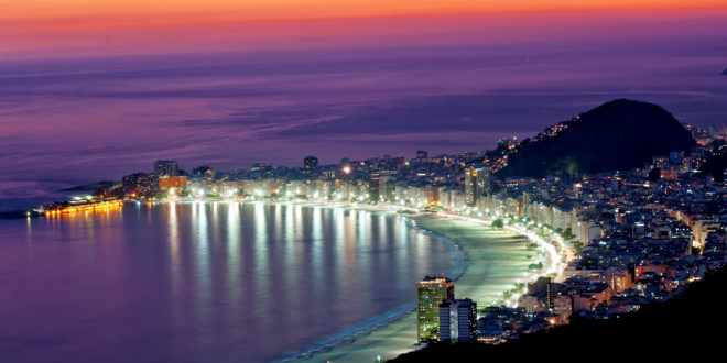 a city with lights on the beach