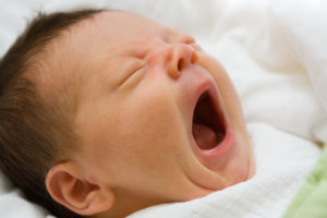 a baby yawning with its mouth open