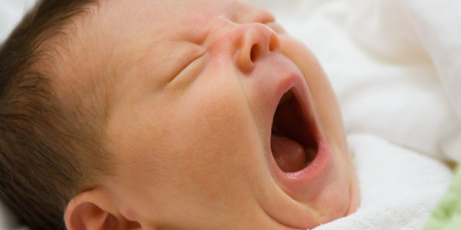 a baby yawning with its mouth open