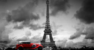 a red car in front of Eiffel Tower