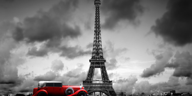 a red car in front of Eiffel Tower