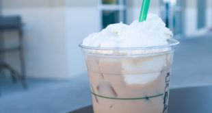 a cup of coffee with whipped cream and straw