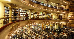 a large library with many books on the shelves with El Ateneo Grand Splendid in the background