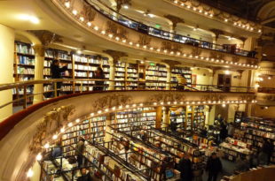 a large library with many books on the shelves with El Ateneo Grand Splendid in the background