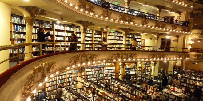 a large library with many books on the shelves with El Ateneo Grand Splendid in the background