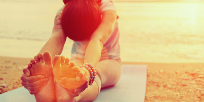 a woman doing yoga on the beach