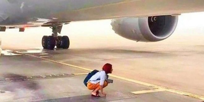 a woman kneeling on the ground with a bag on her back