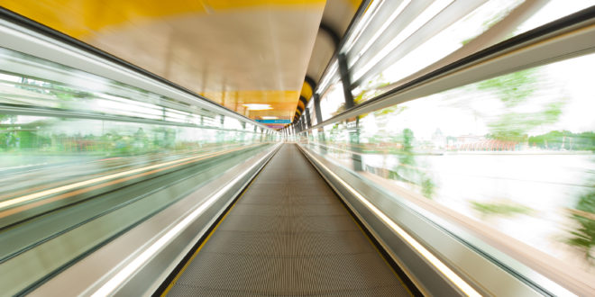 a moving walkway with a yellow ceiling