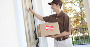 a man holding a box and opening a door