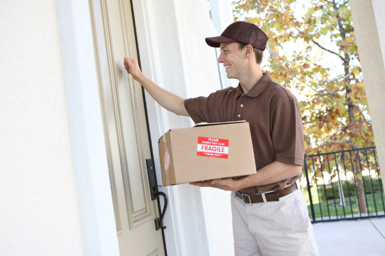 a man holding a box and opening a door