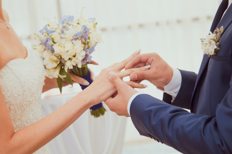 a man putting a ring on a woman's hand