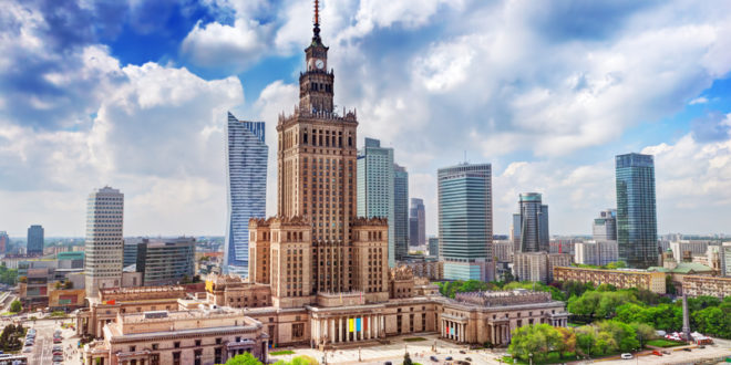 a large building with a tower and a city skyline