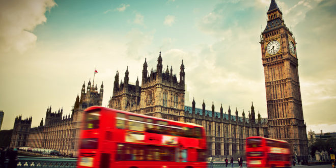 a double decker bus in front of a clock tower