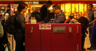 a man standing at a counter in a airport