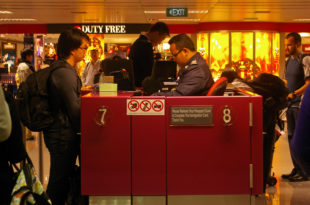 a man standing at a counter in a airport