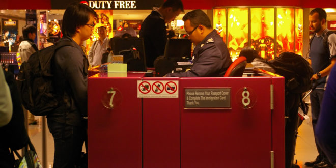 a man standing at a counter in a airport