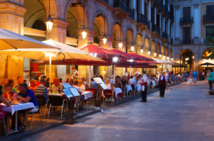 a group of people sitting at tables outside a building