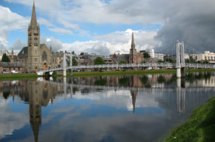 a bridge over a body of water with a church and buildings