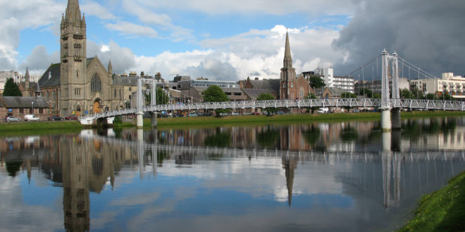a bridge over a body of water with a church and buildings