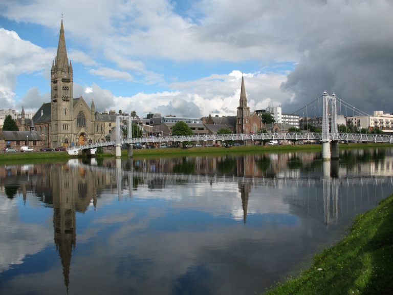 a bridge over a body of water with a church and buildings