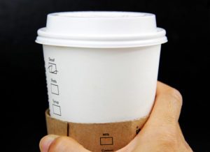 a hand holding a white cup