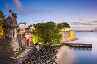 a body of water with a stone wall and a walkway