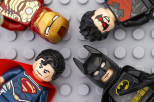 Four Lego Super Heroes minifigures on gray baseplate