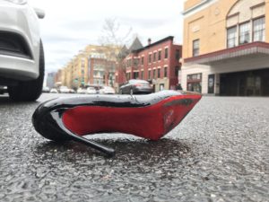 a black and red high heeled shoe on the street